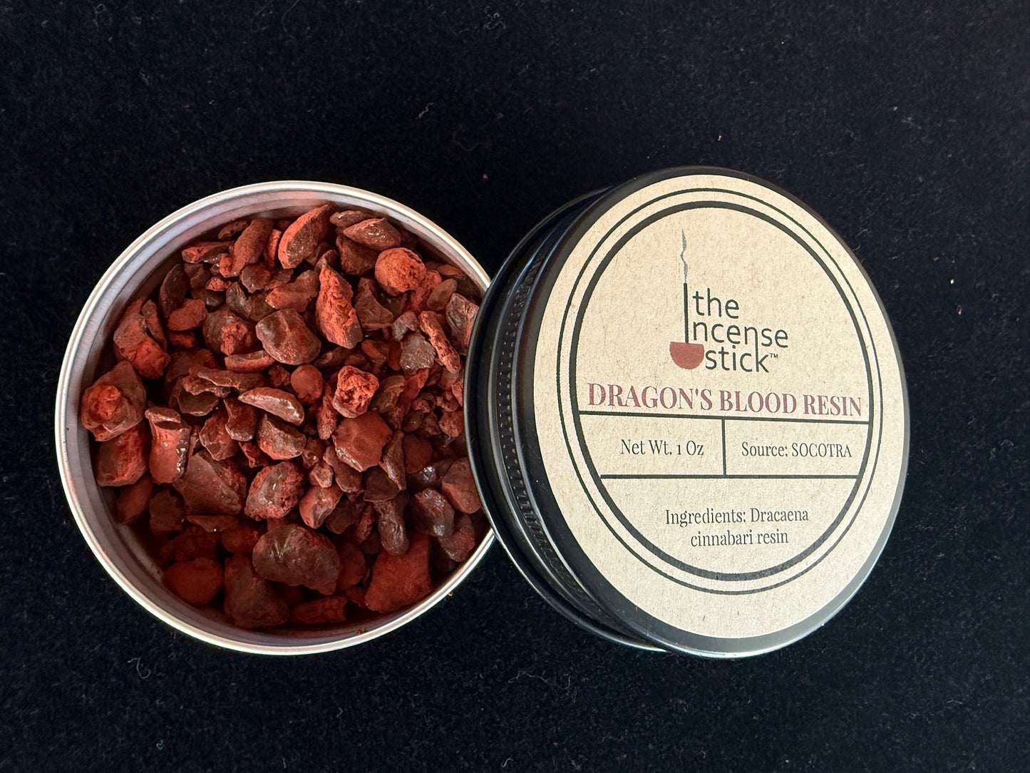 Open tin of red resin with 'Dragon's Blood Resin' label on a black background
